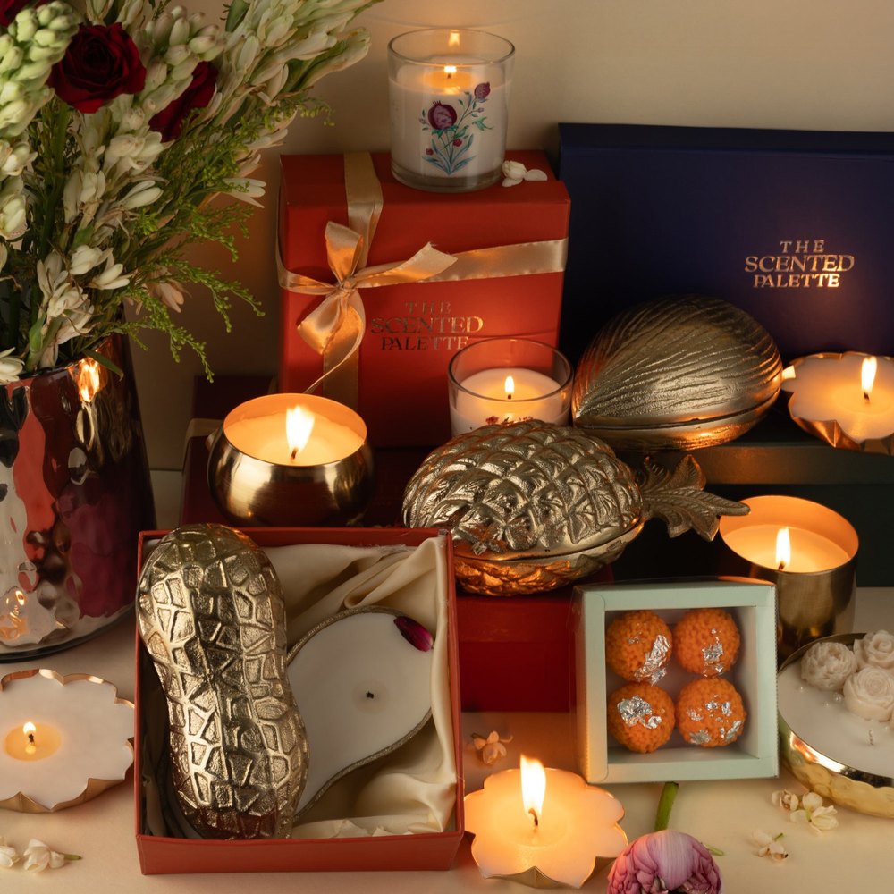 Riwayat Diwali candles lit among gold keepsakes, gift boxes, tuberoses and roses
